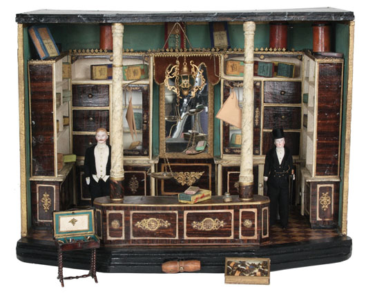Victorian tobacco/cigar shop room box with deluxe appointments and two finely dressed Simon & Halbig gentlemen dolls in attendance; attributed to Christian Hacker, $21,850. Noel Barrett Auctions image.